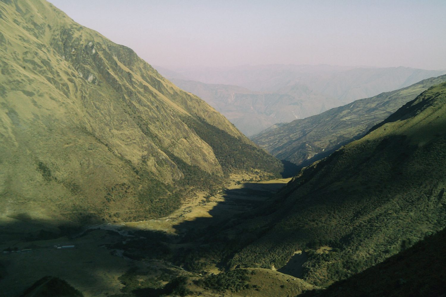 Lush tropical green river valley with dirt road on the Salkantay Trek near Colpapampa