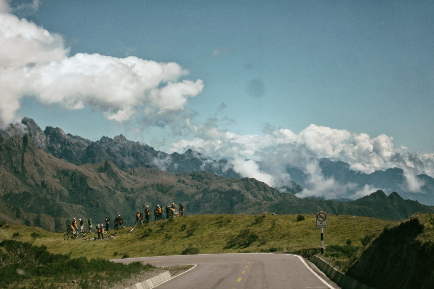 Group of mountain bikers taking a break on a high green ridge road in the Andes