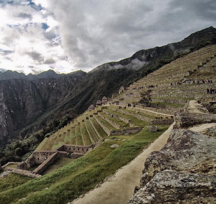Inca agricultural terraces and stone ruins climbing the steep hillside of Machu Picchu citadel