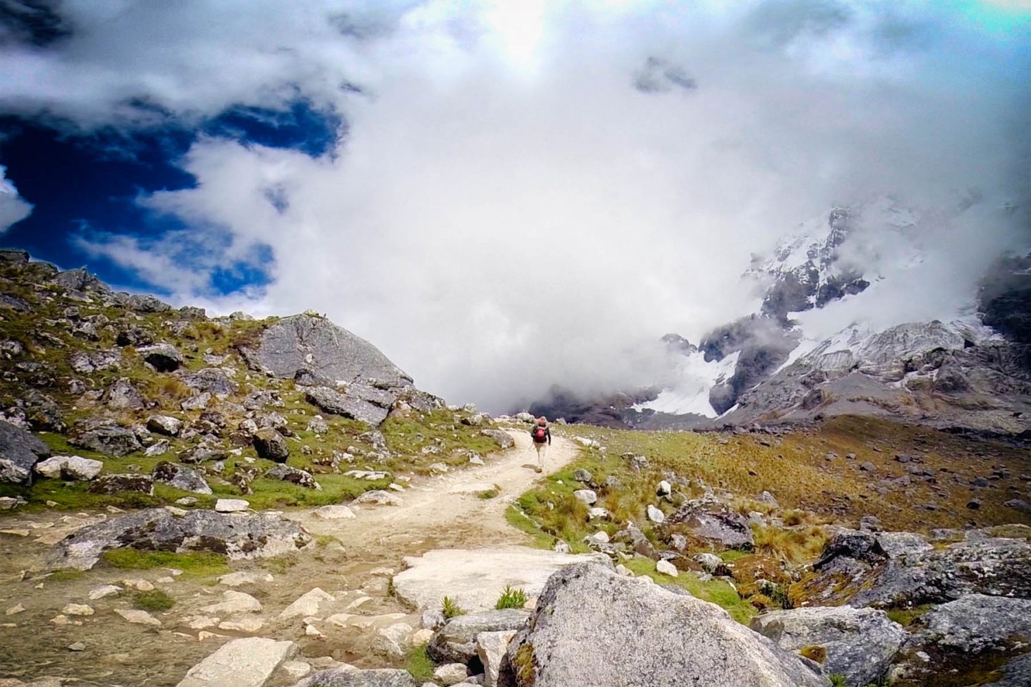 Group of hikers standing proudly in front of the massive Salkantay glacier peak in Cusco