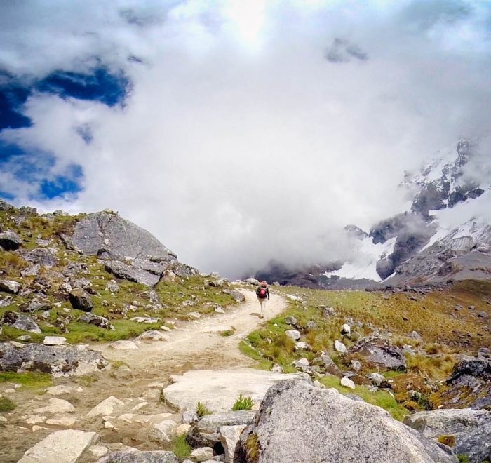 Group of hikers standing proudly in front of the massive Salkantay glacier peak in Cusco