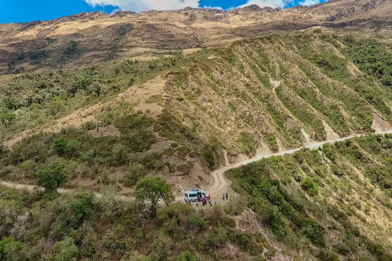 Hikers walking on a high alpine trail beneath the towering snow glaciers of Salkantay mountain