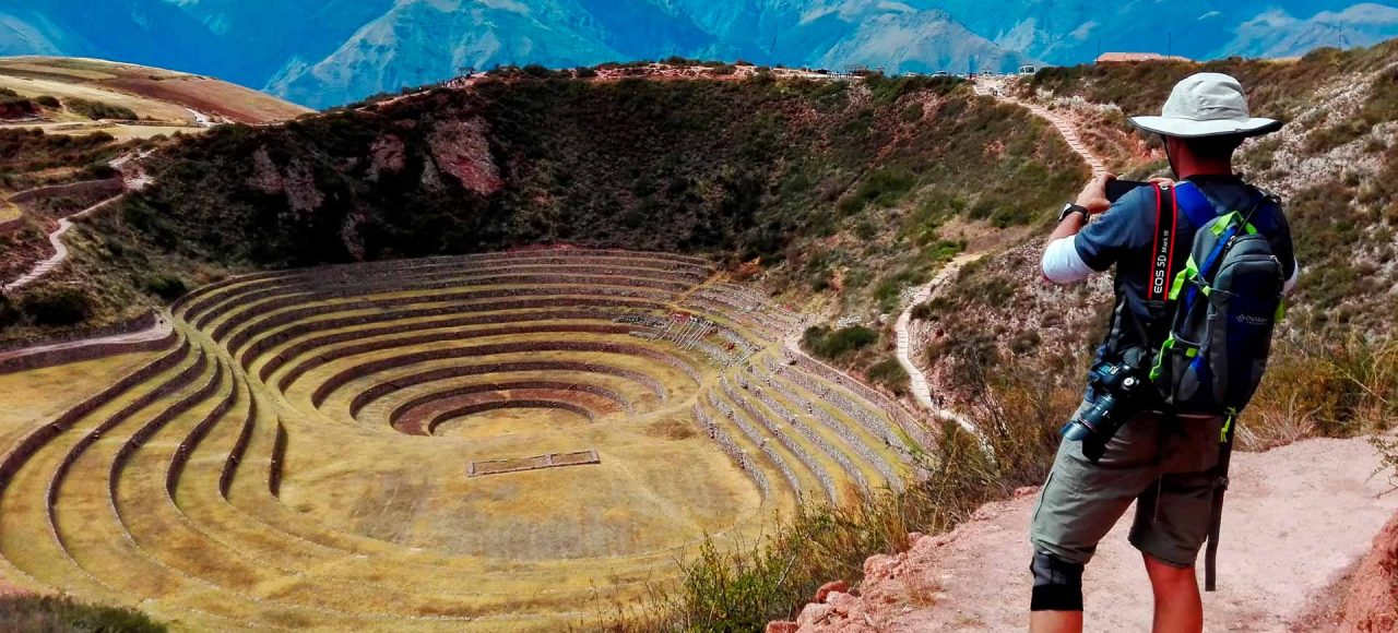 Caminantes explorando el laboratorio agrícola inca de Moray durante el Chimoma Trek