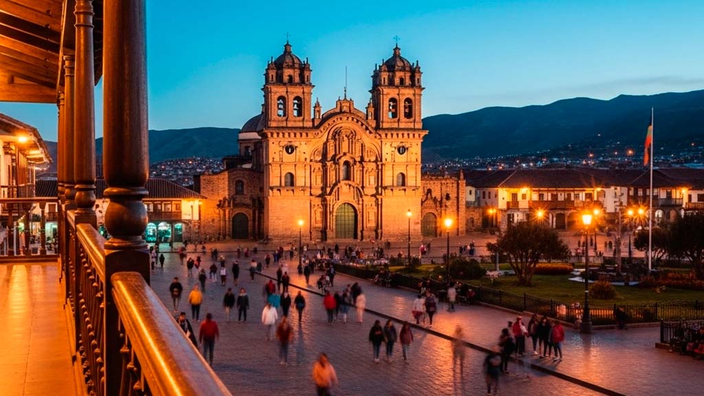 A vibrant street scene in Cusco at night, with the historic Plaza de Armas illuminated and travelers enjoying the lively atmosphere outside a bar.