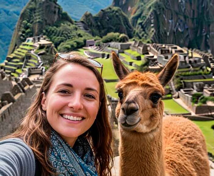 Turista europea tomando una selfie con una alpaca en Machu Picchu, Perú. Uno de los mejores lugares para tomarte fotos con alpacas y llamas.