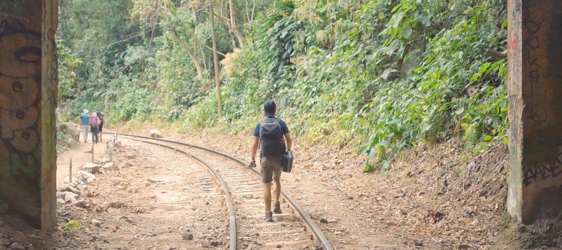 turista caminando por las vías del tren en el tour e aventura a Machu Picchu
