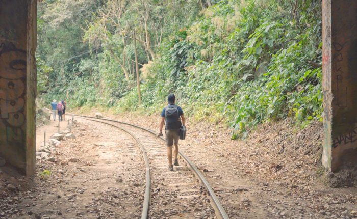 turista caminando por las vías del tren en el tour e aventura a Machu Picchu