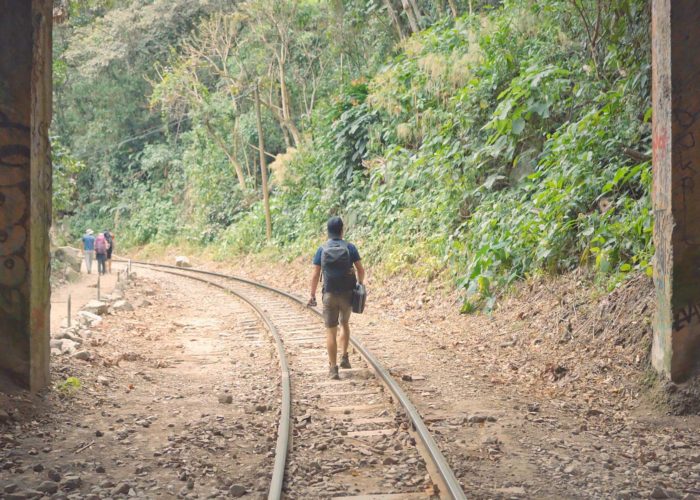 turista caminando por las vías del tren en el tour e aventura a Machu Picchu