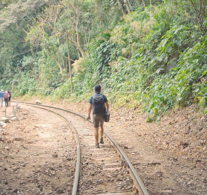 turista caminando por las vías del tren en el tour e aventura a Machu Picchu