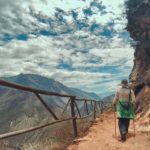 Un caminante observando el sendero en zigzag que muestra cómo llegar a Choquequirao, con el imponente cañón del río Apurímac de fondo.