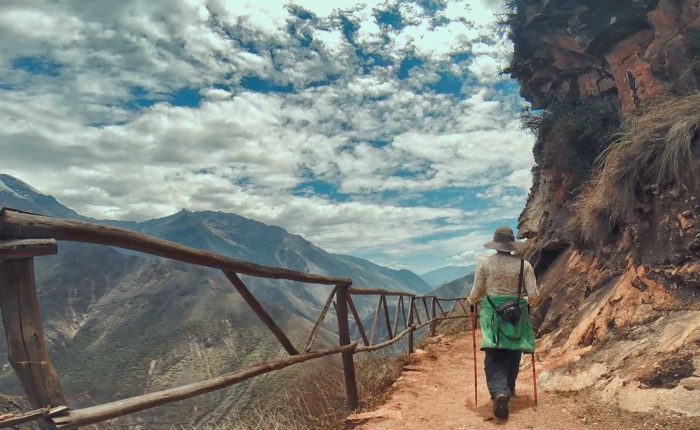 Un caminante observando el sendero en zigzag que muestra cómo llegar a Choquequirao, con el imponente cañón del río Apurímac de fondo.