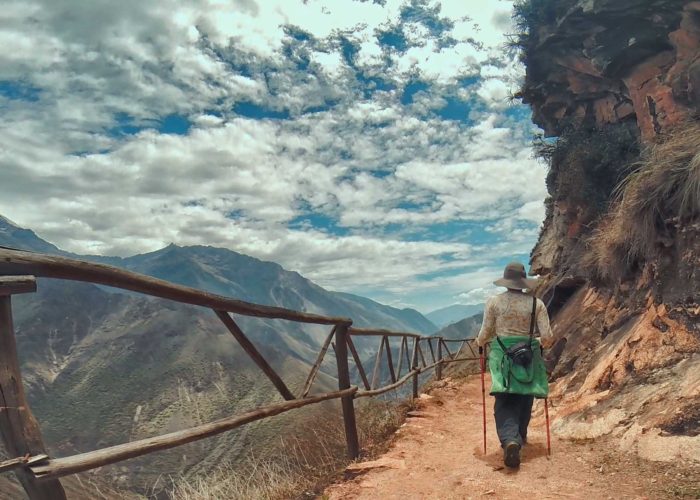 Un caminante observando el sendero en zigzag que muestra cómo llegar a Choquequirao, con el imponente cañón del río Apurímac de fondo.