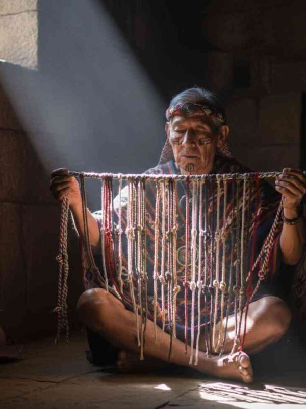Un sabio Quipucamayoc en una cámara de piedra iluminada por un rayo de sol, examinando el código secreto de los quipus, la escritura perdida del Imperio Inca.