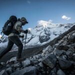 Un viajero en medio del ascenso del día 2 en Salkantay, con el imponente pico nevado del Apu Salkantay de fondo