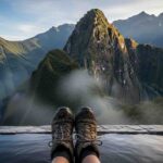 Un par de botas de trekking descansando al borde de los baños termales mientras un viajero se relaja, mostrando qué hacer en Aguas Calientes después del Camino Inca