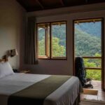 Cama confortable en un lodge del tour premium Inka Jungle, con vistas a la selva peruana