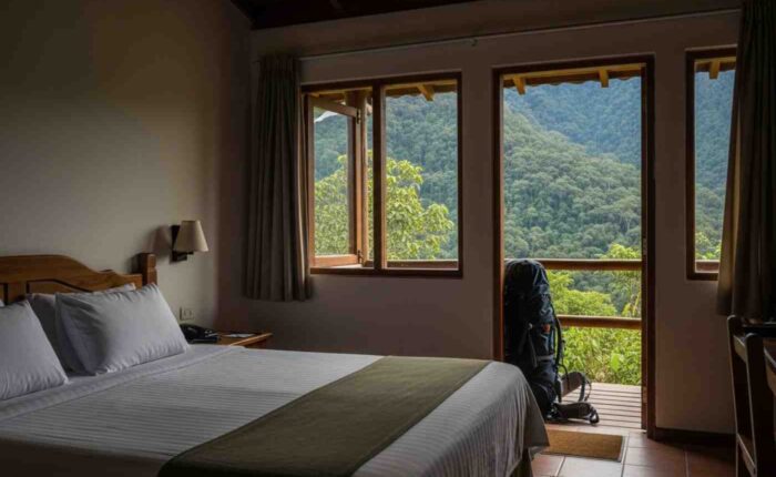 Cama confortable en un lodge del tour premium Inka Jungle, con vistas a la selva peruana