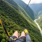 Un viajero haciendo zipline en su viaje a Machu Picchu, volando sobre el valle verde de Santa Teresa