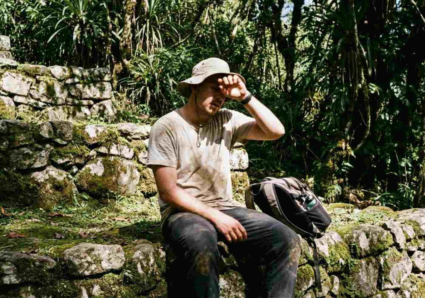 Senderista caminando bajo sol intenso en la selva alta, mostrando el clima de la mejor época Inca Jungle Backpacker en temporada seca