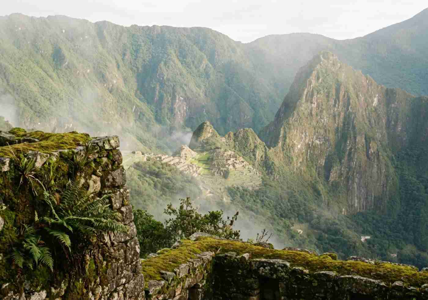 Vista distante de Machu Picchu entre la niebla y vegetación densa desde el mirador de Llactapata