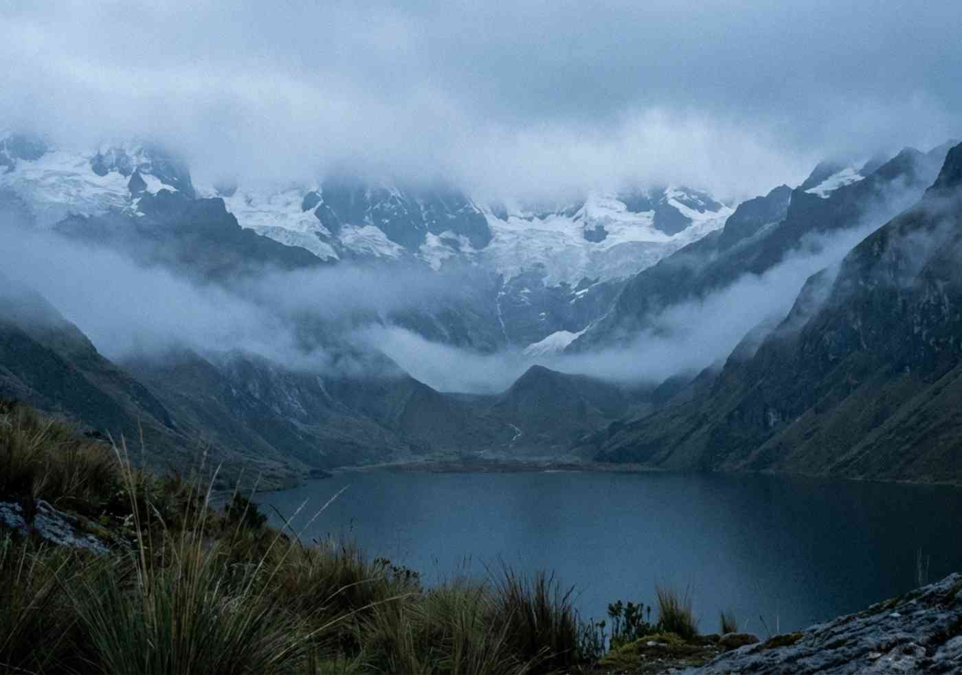 Laguna Wilcacocha en Huaraz con vista a los glaciares de la Cordillera Blanca bajo un cielo nublado